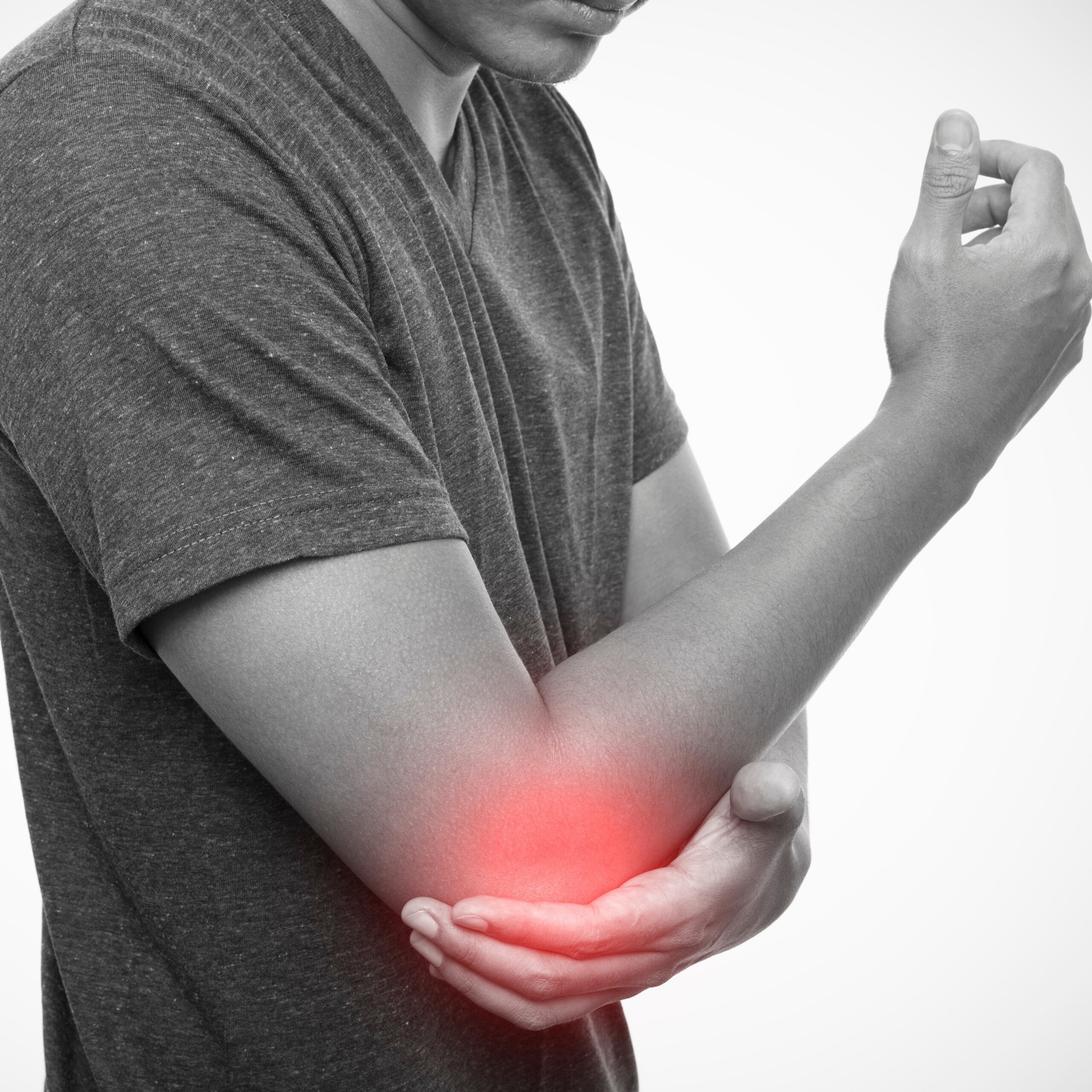 A person holding their elbow in pain, with a red highlight indicating inflammation or discomfort in the joint, representing tennis elbow or elbow joint pain.
