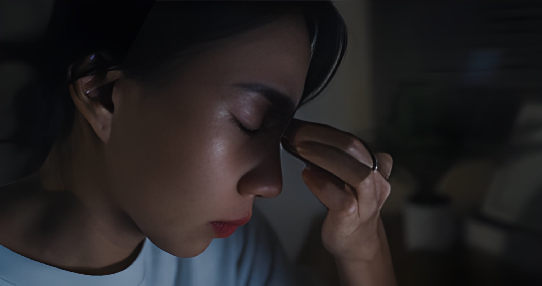 Dark Circle Treatment in Ayurveda | Natural Under-Eye Healing A woman touching her eyes with visible fatigue and under-eye darkness, representing dark circle treatment in Ayurveda.