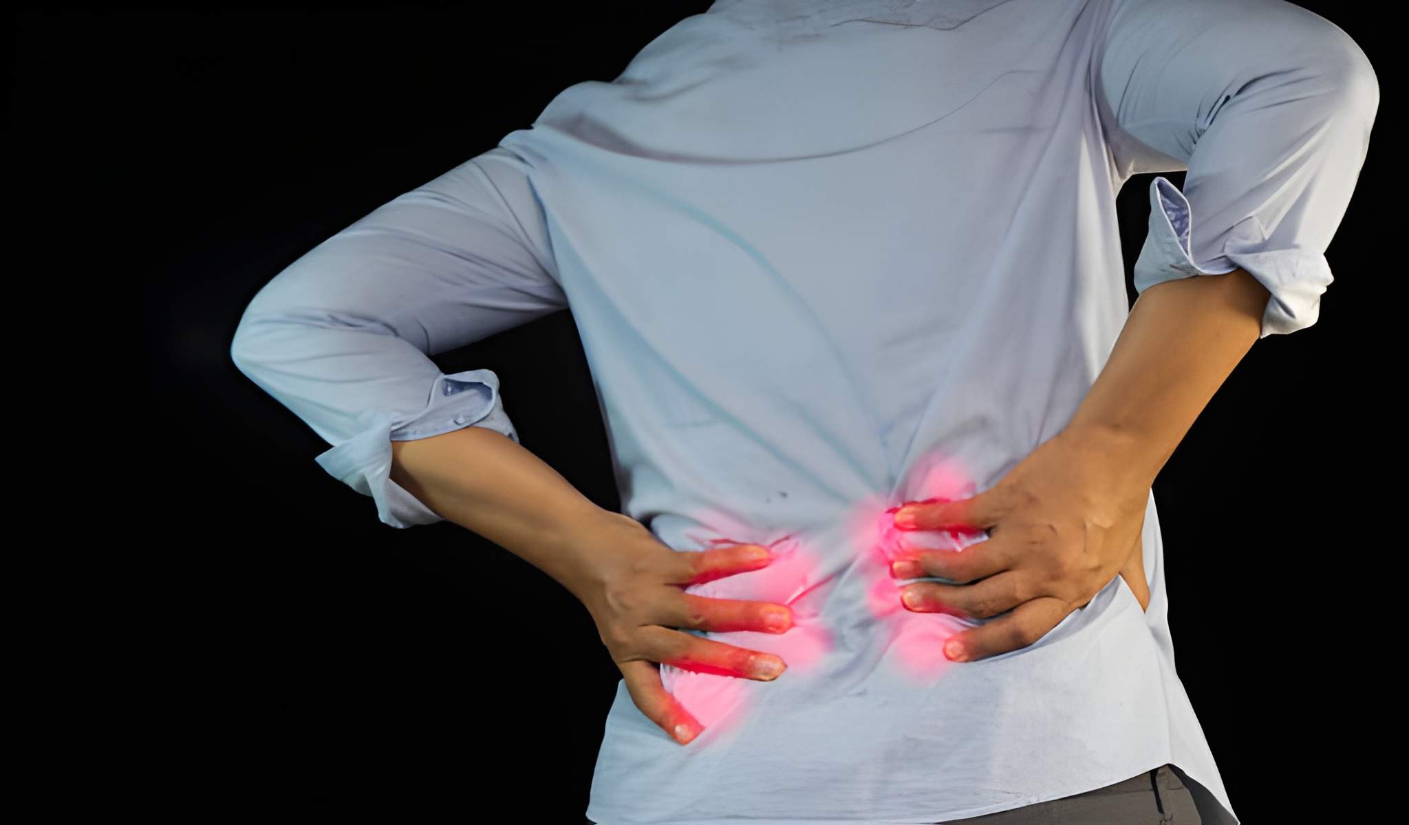 Person holding lower back in pain, highlighting inflammation and symptoms of psoriatic arthritis back pain.