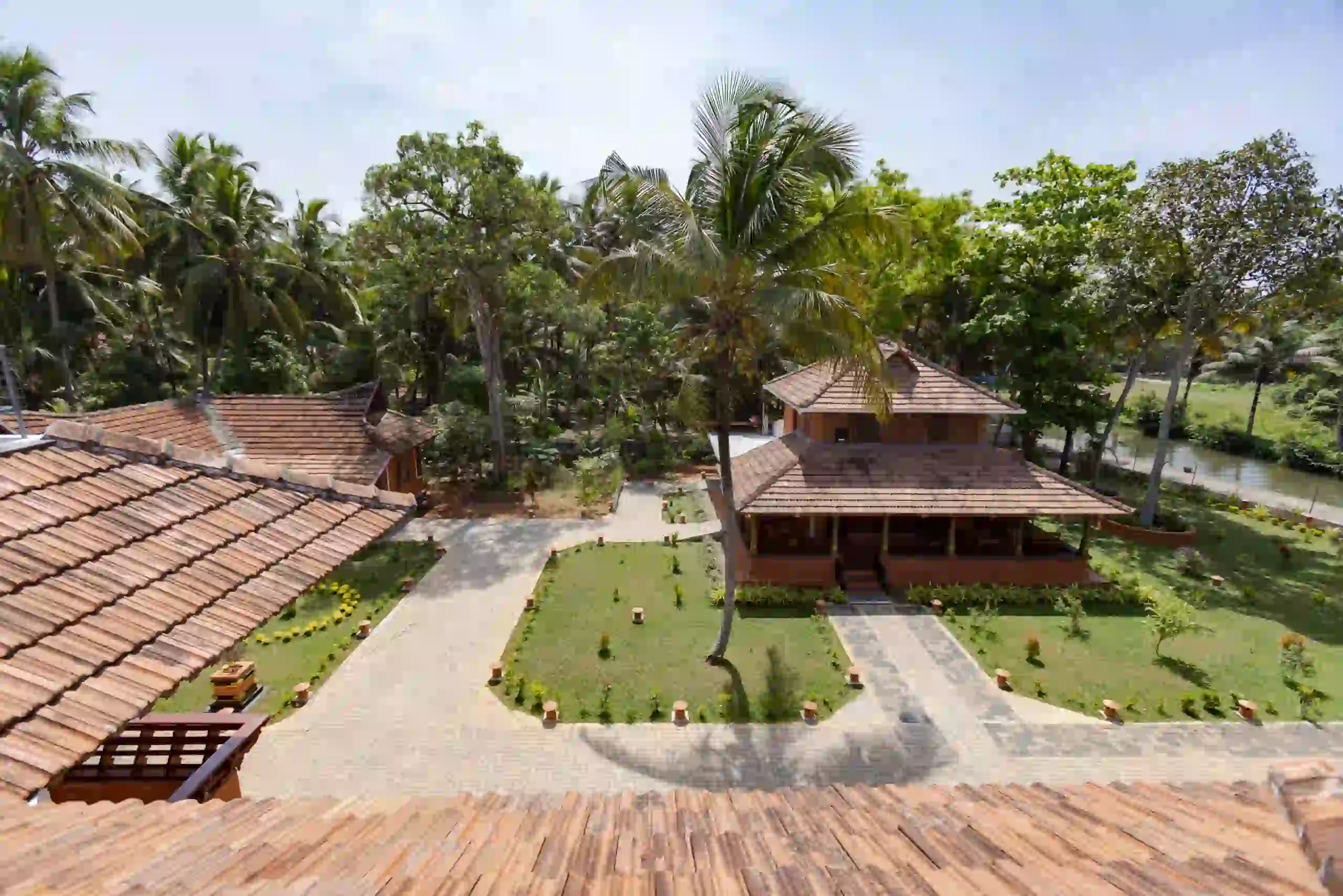 Aerial view of Dheemahi Ayurvedic Village surrounded by tropical greenery in Kumarakom